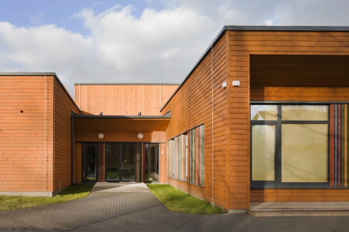 sprimontblue Bâtiment scolaire moderne en bois avec des accents colorés et une entrée spacieuse.