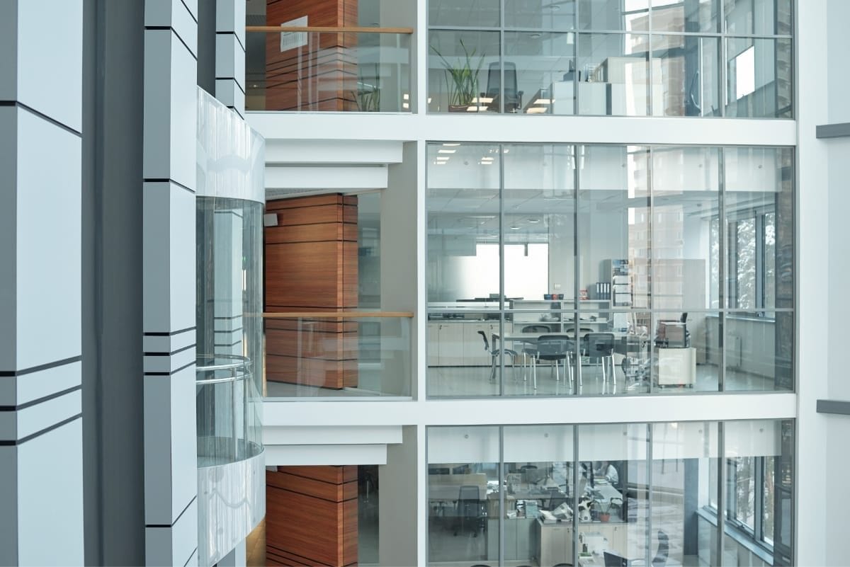 sprimontblue Intérieur d'un immeuble de bureaux moderne en verre avec ascenseur et boiseries.